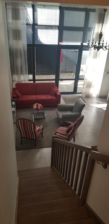 a living room with a red couch and chairs at Le jardin de l&#39;horloge in La Rochelle