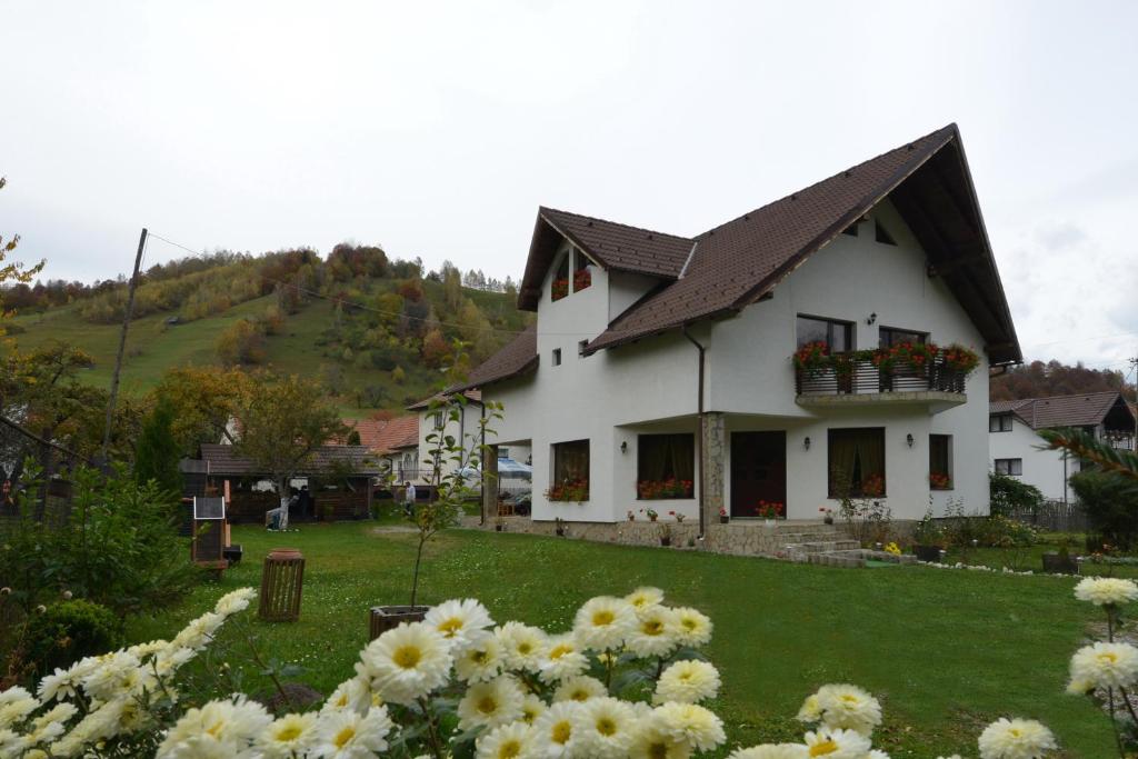 a white house with flowers in front of it at Bucuria Muntelui in Bran