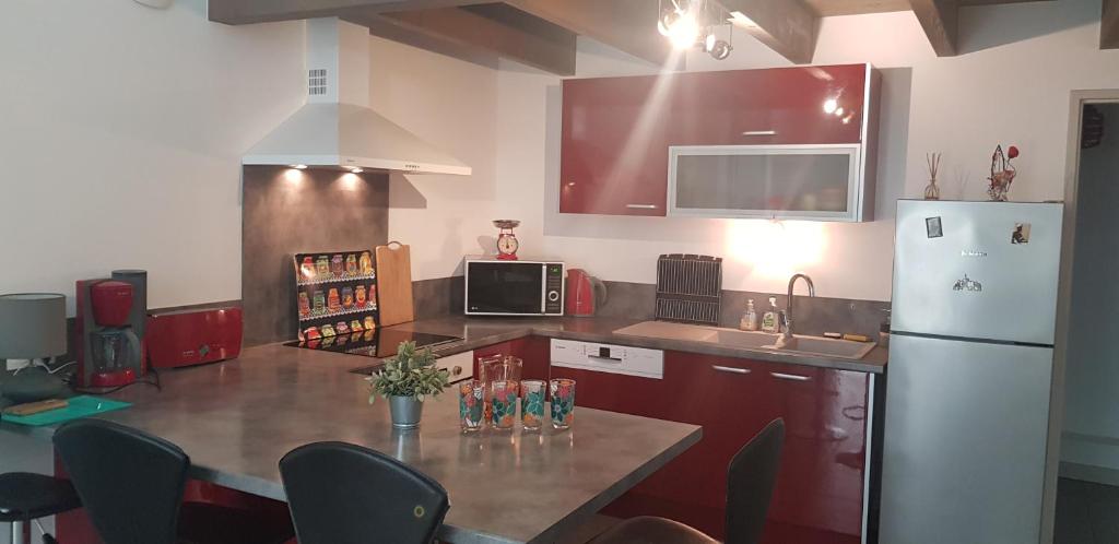 a kitchen with a refrigerator and a table with chairs at Le jardin de l&#39;horloge in La Rochelle