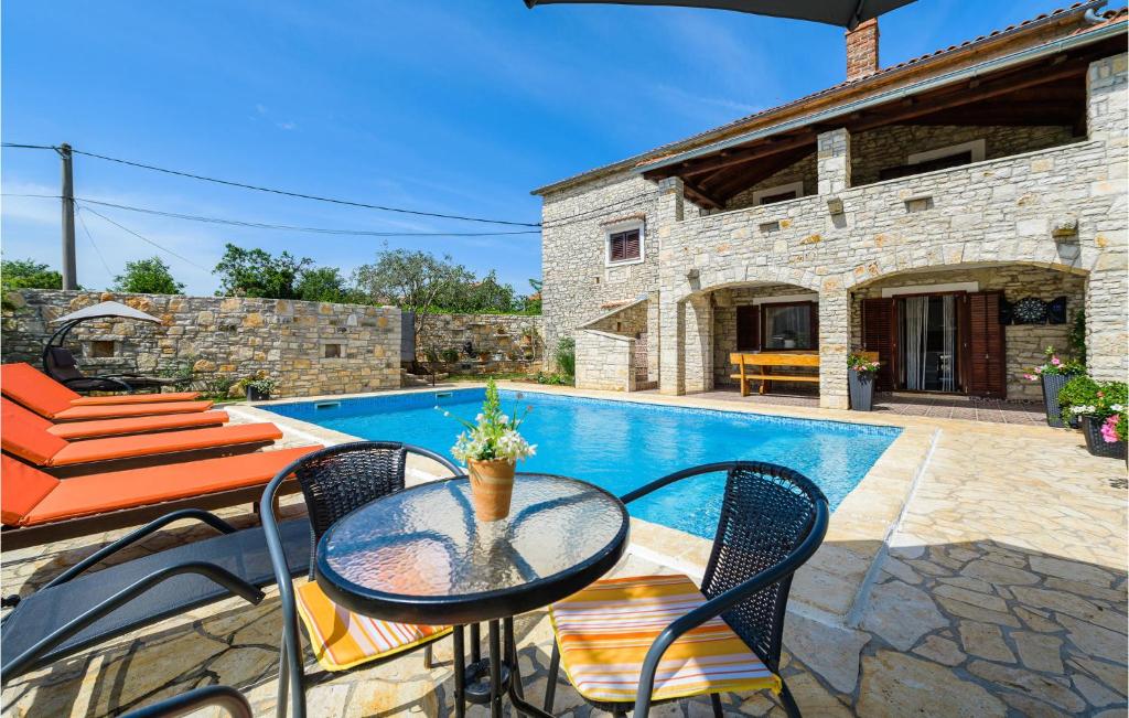 a patio with a table and chairs next to a pool at Amazing Home In Svetvincenat With Wifi in Svetvinčenat