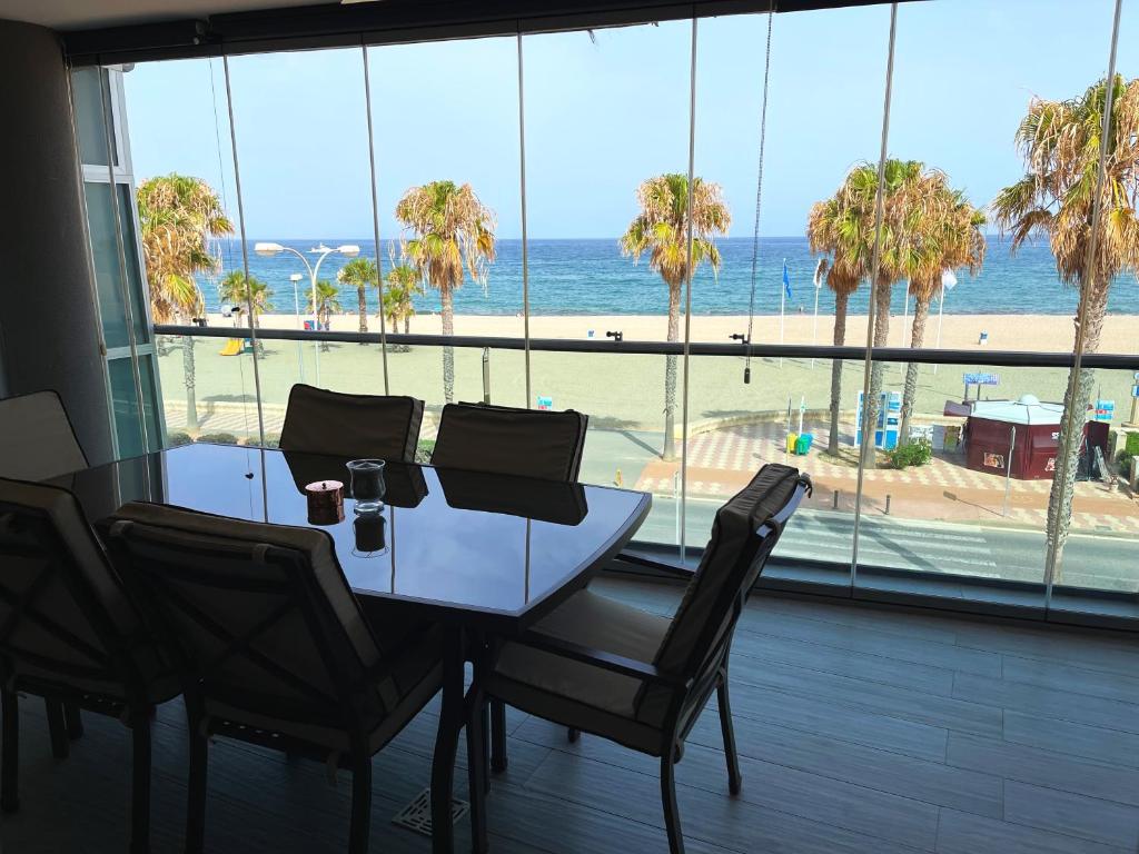 a dining room table with chairs and a view of the beach at Casa Dru in Roquetas de Mar
