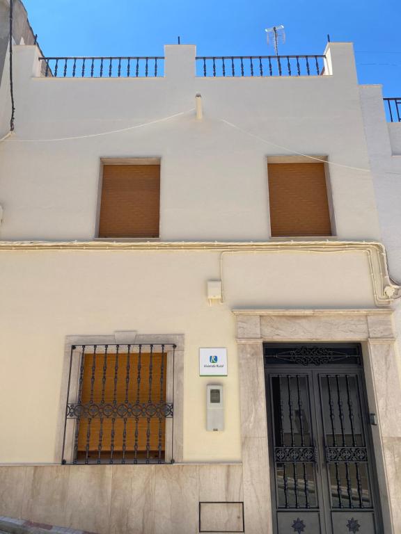 a white building with two windows and a door at 1001 maneras para endulzarte la vida in Porcuna