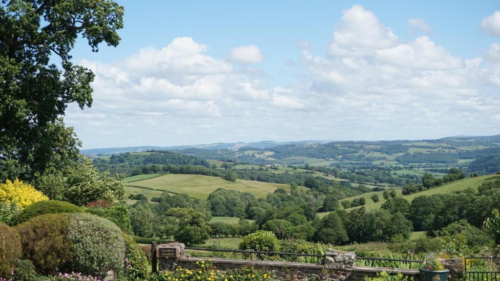 Blick auf die Hügel aus dem Garten in der Unterkunft Shepherd's Watch Cottage - 5* Cyfie Farm with private hot tub in Llanfyllin