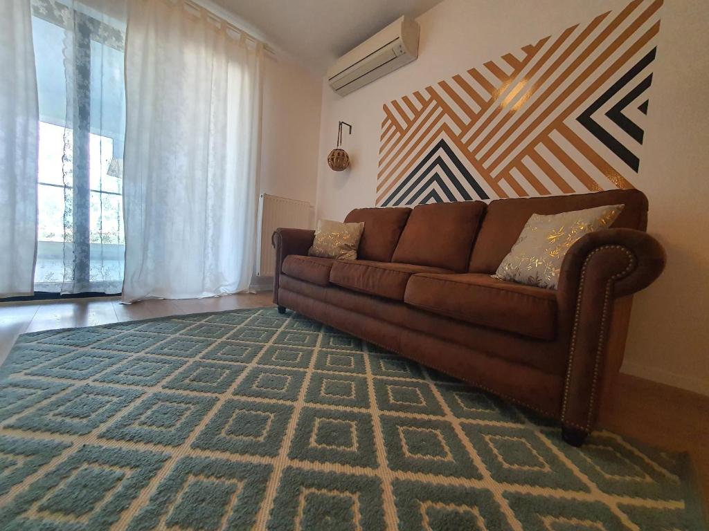 sala de estar con sofá marrón y alfombra en Upground14 Residence Apartments, en Bucarest