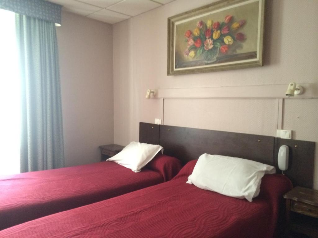 - 2 lits dans une chambre d'hôtel avec des draps rouges dans l'établissement Hôtel Stanislas sans ascenseur, à Paris