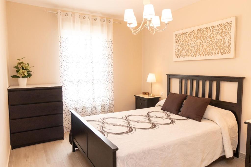 1 dormitorio con 1 cama grande con colcha blanca en La casa de San Martín. Parque Warner, Madrid en San Martín de la Vega