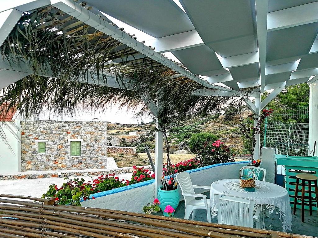 d'une terrasse avec une table et des chaises sous une pergola. dans l'établissement Rou Garden House, à Karpathos