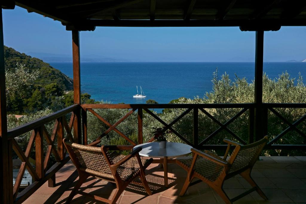 a patio with a table and chairs and the ocean at Skiathos Villa Ira in Koukounaries
