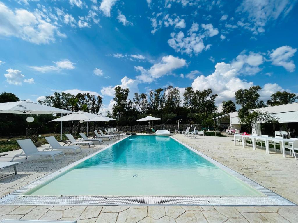 einen Pool mit Liegestühlen und Sonnenschirmen in der Unterkunft Luxury Home & Pool in Lequile
