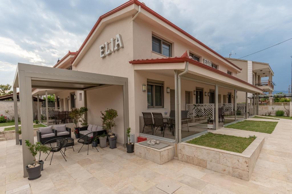a house with a patio with chairs and tables at Elia Luxury Apartments in Stavros