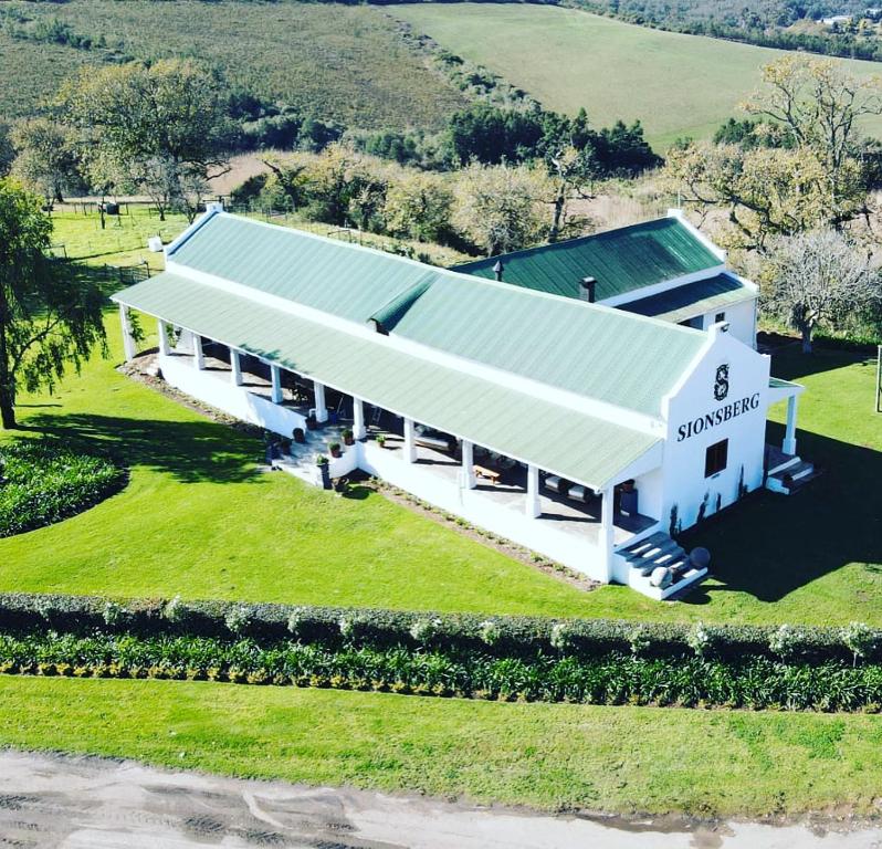 an aerial view of a white building with a green roof at Sionsberg Farmstay in Riversdale
