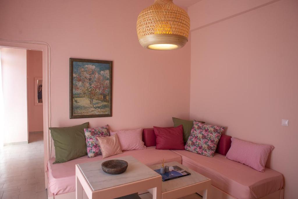 a living room with a pink couch and a table at Ann's apartment II in Lixouri