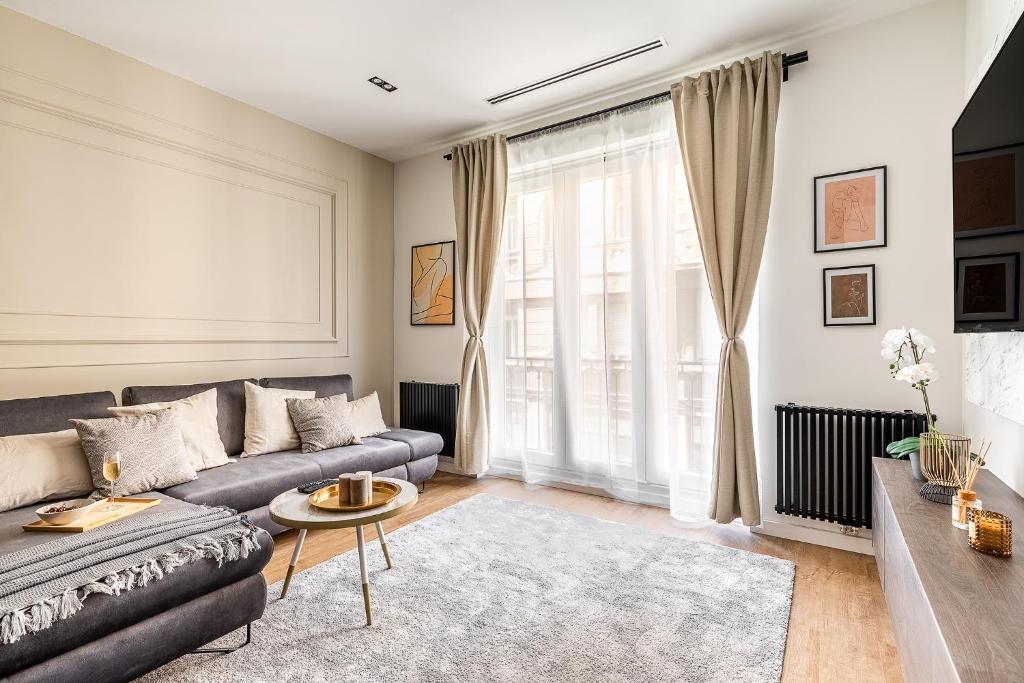 a living room with a couch and a large window at Asboth Boutique Budapest in Budapest