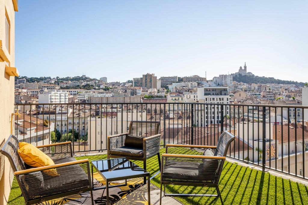 d'un balcon avec des chaises et une vue sur la ville. dans l'établissement Marseille: Superbe vue sur Notre-Dame de la Garde, à Marseille