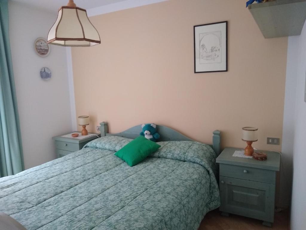1 dormitorio con 1 cama con edredón verde en Campitello House, en Campitello di Fassa