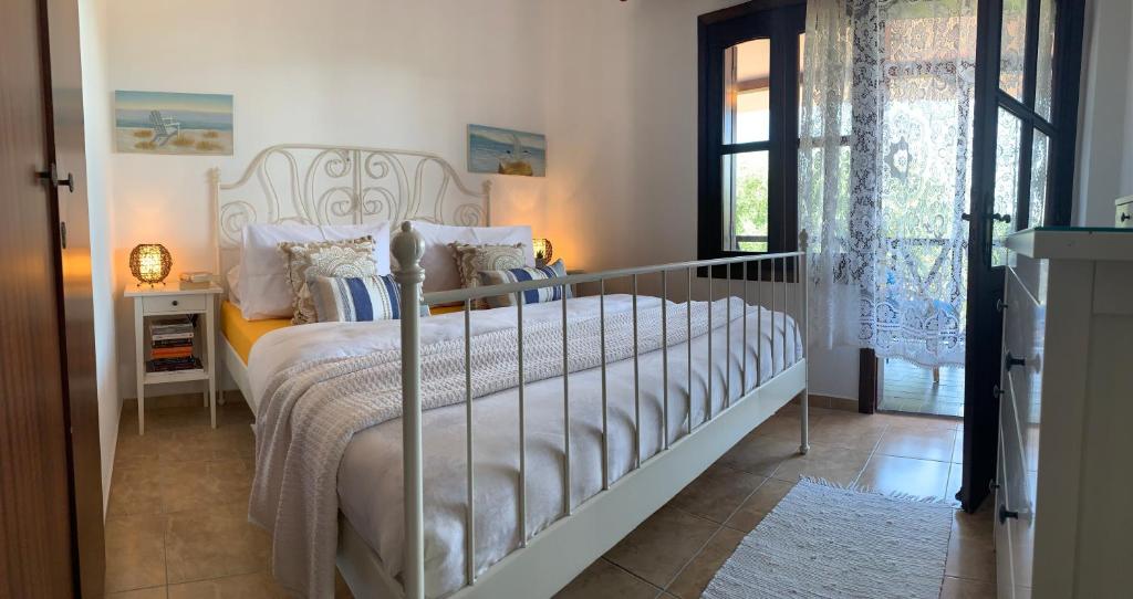 a bedroom with a large bed with a white bedspread at Mikiverna Seas the Day ! in Kalivia Poligirou