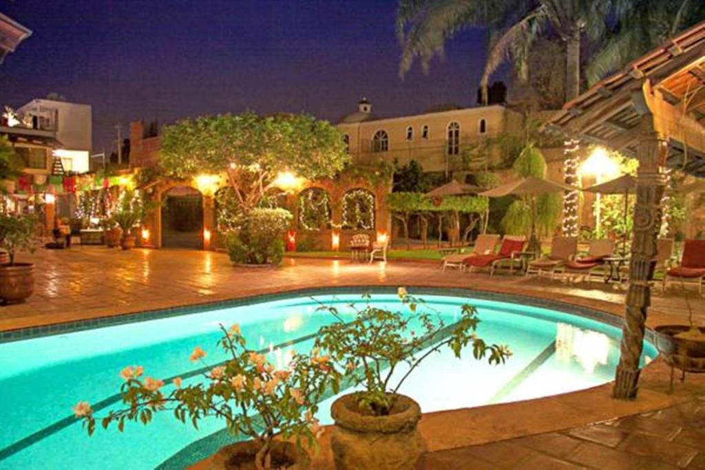 a large swimming pool in a courtyard at night at Quinta Don Jose Boutique Hotel in Guadalajara