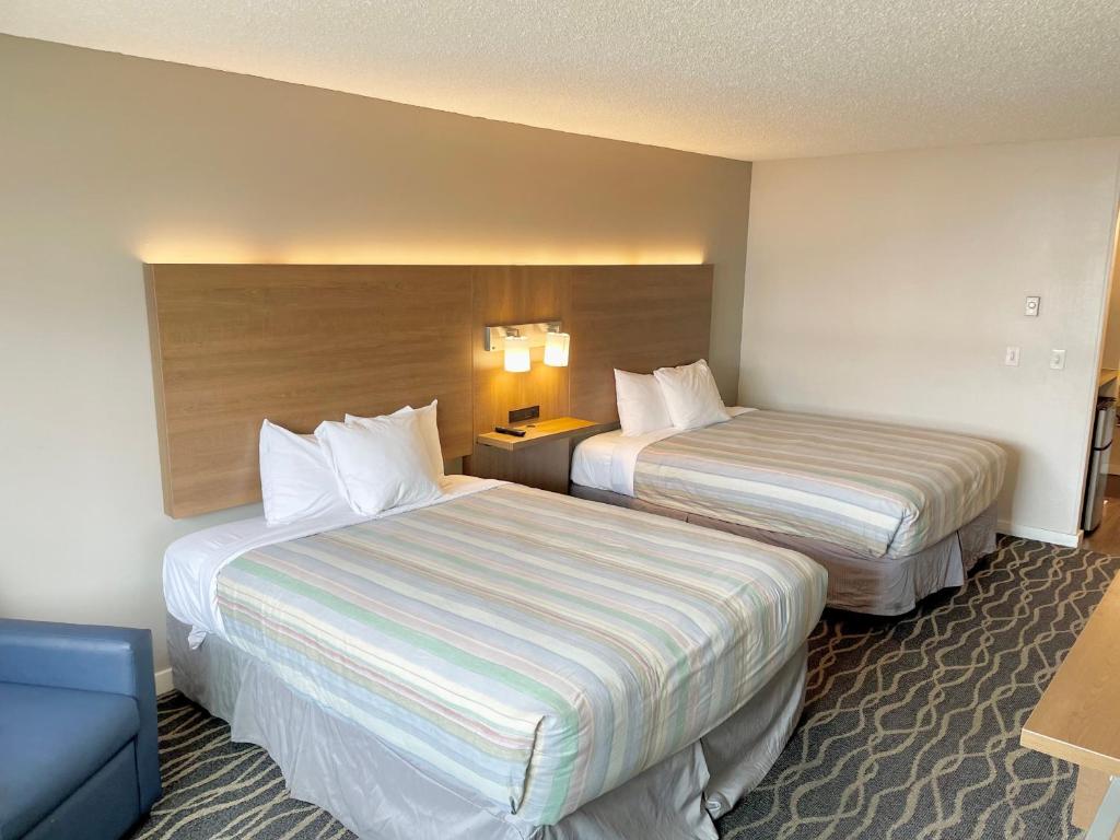 Habitación de hotel con 2 camas y sofá en Dunes Motel Hillsboro, en Hillsboro