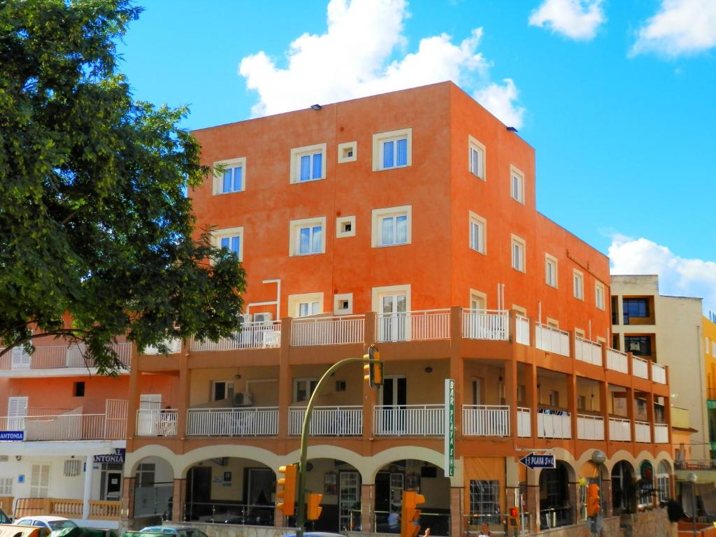 an orange building with a balcony on a street at Hotel Playa Sol in El Arenal