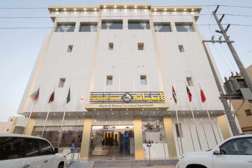 un edificio con banderas delante en فندق ابيات الشمال en Rafha