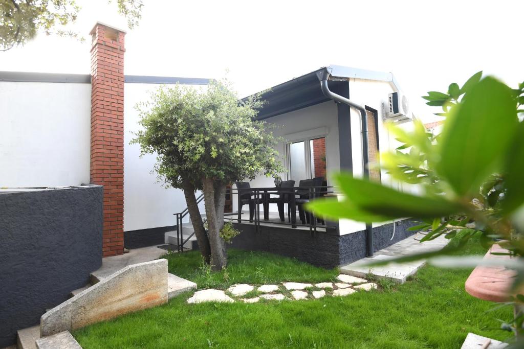 a house with a table and chairs in the yard at Apartment by the sea Renata in Punta Skala in Petrcane