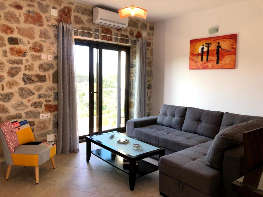a living room with a couch and a table at Oikia Stone House in seaside Kalo Chorio in Agios Nikolaos