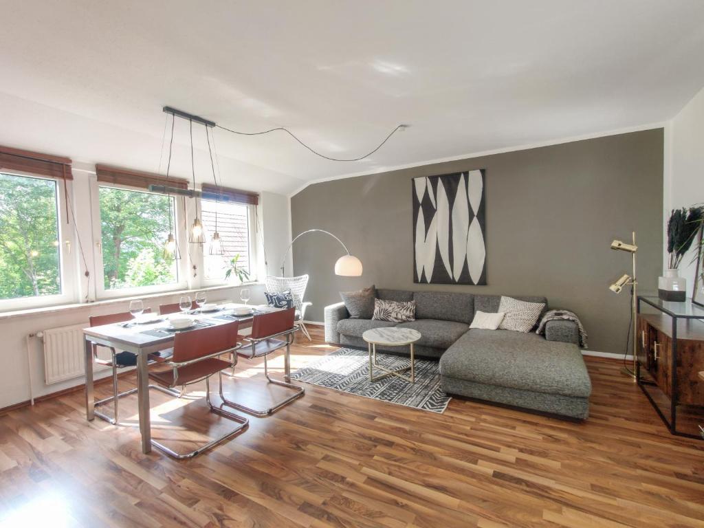 een woonkamer met een bank en een tafel bij INIKAMA: Designer Apartment im Grünen – Netflix in Rosengarten