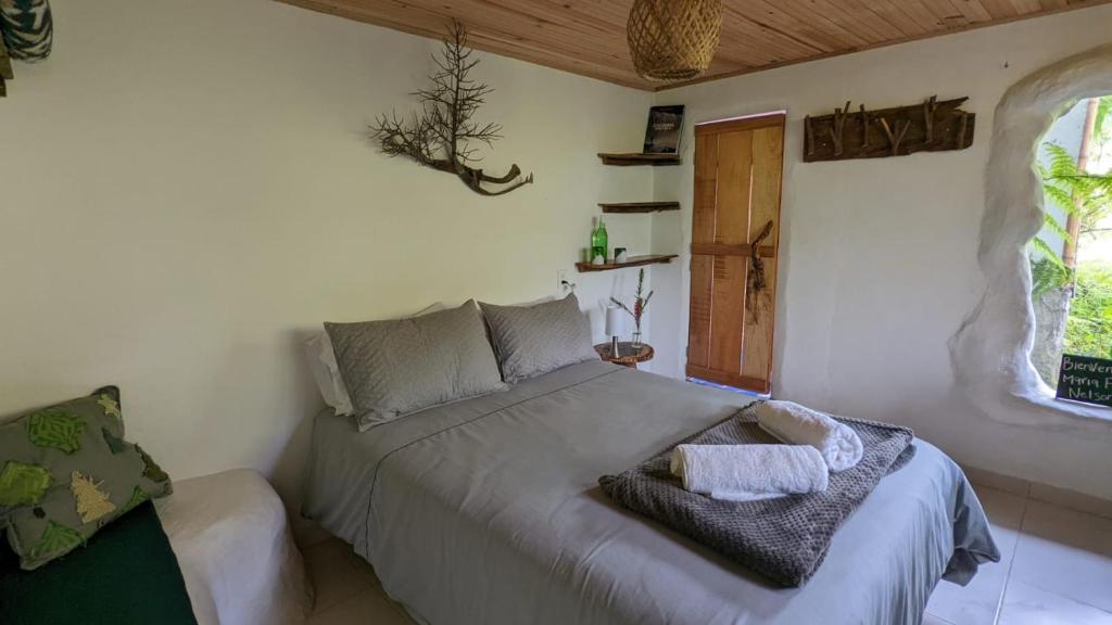 1 dormitorio con cama y ventana en Finca Flora del Rio, Habitacion Las Orquideas en Pijao