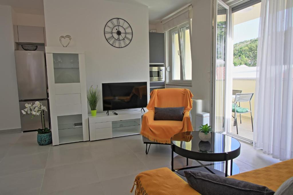 a living room with an orange chair and a tv at Bonaca in Senj