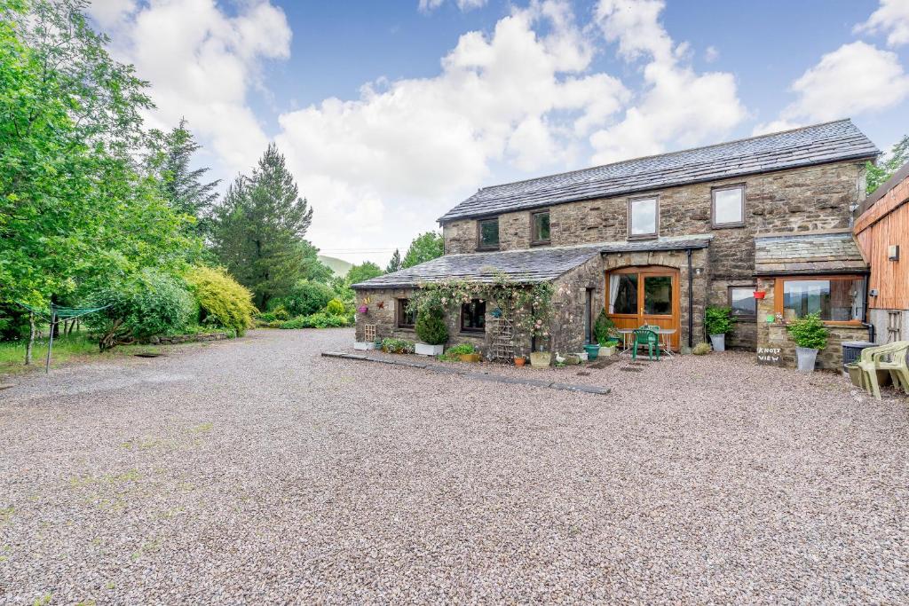 an old stone house with a gravel driveway at Knott View in Milnthorpe