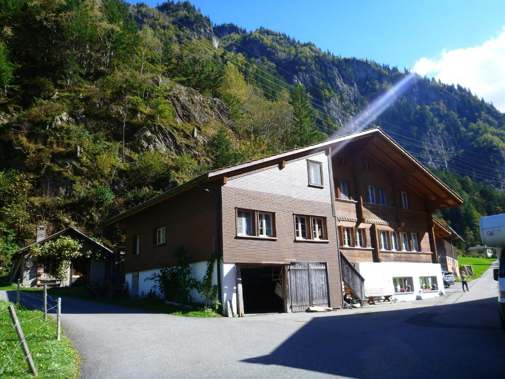 ein braunes Gebäude mit einem Berg im Hintergrund in der Unterkunft Ferienwohnung Berner Oberland - Guttannen in Guttannen