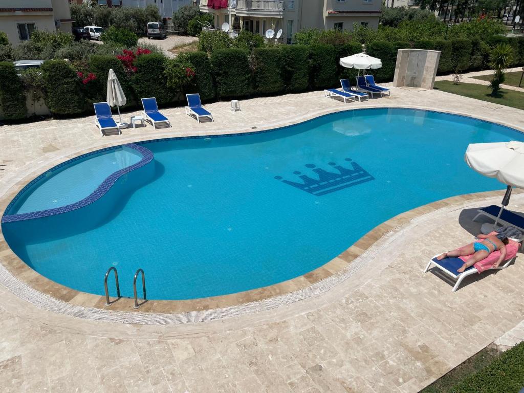 una gran piscina con sillas y sombrillas en Fantastic Apt-2 min walk from Belek Cent’r Antalya region, great for golf lovers, en Belek