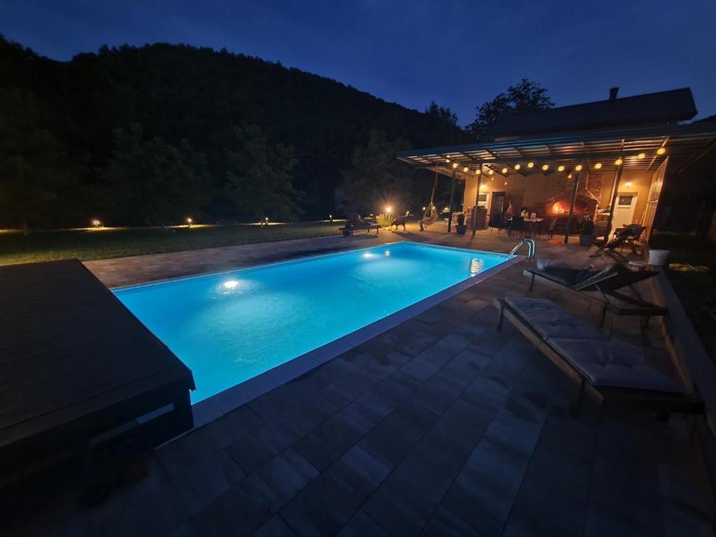 - une piscine en face d'une maison la nuit dans l'établissement Soko holiday home Bihac, à Bihać