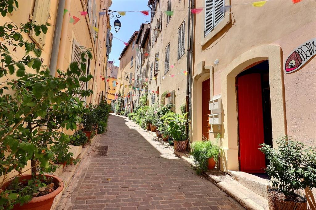 a narrow street with plants on the sides of buildings at La Sardine du Panier® in Marseille