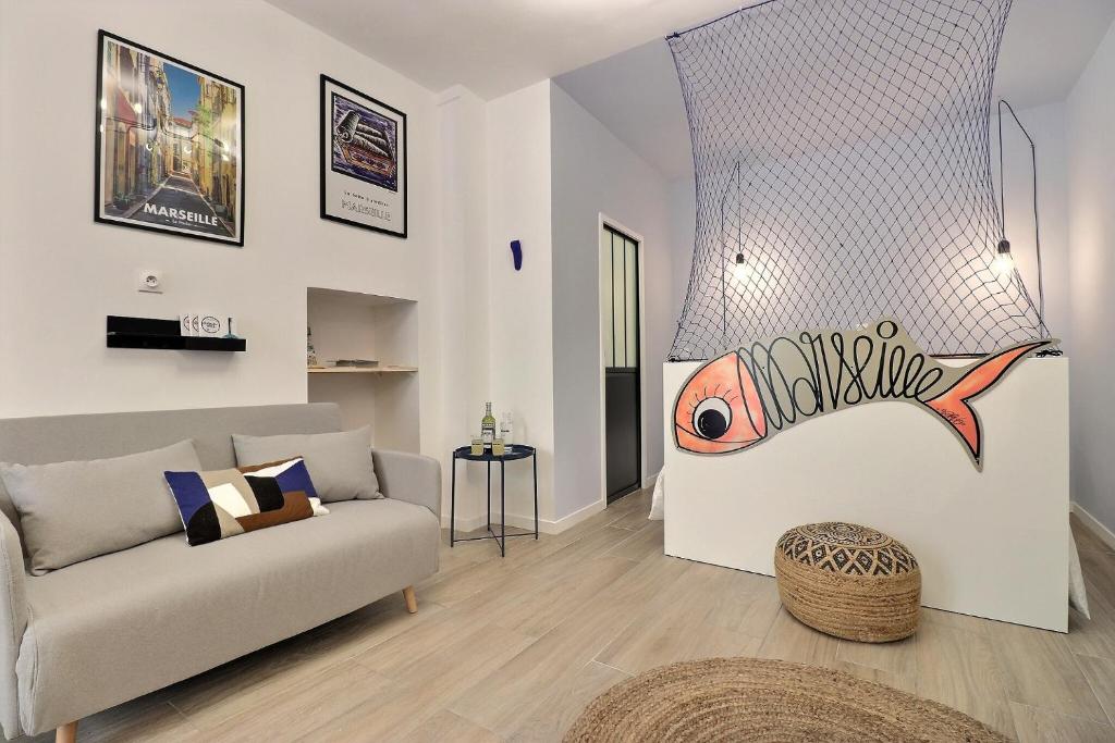 a living room with a couch and a fish on the wall at La Sardine du Panier® in Marseille
