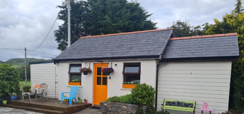 a small white cottage with an orange door at Lisheens Lodge in Bantry