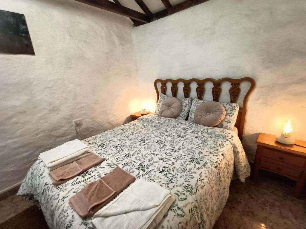 a bedroom with a bed and two lamps on tables at Casa rural en el Parque Nacional de Garajonay en la Isla de La Gomera, Alonso y Carmen in Santa Cruz de Tenerife