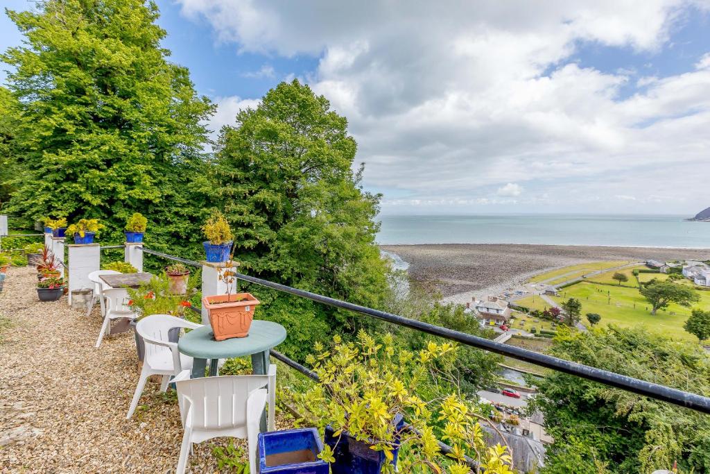 a balcony with chairs and a view of the ocean at Clooneavin Apartment 8 in Lynmouth