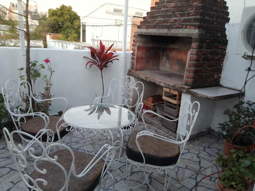 un patio con mesa, sillas y chimenea en Depto LA QUILMES en Concepción del Uruguay