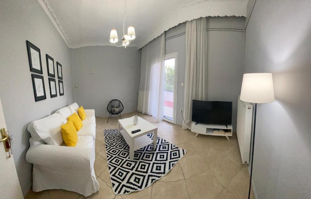 a living room with a white couch and a tv at Villa Loukia in Corfu
