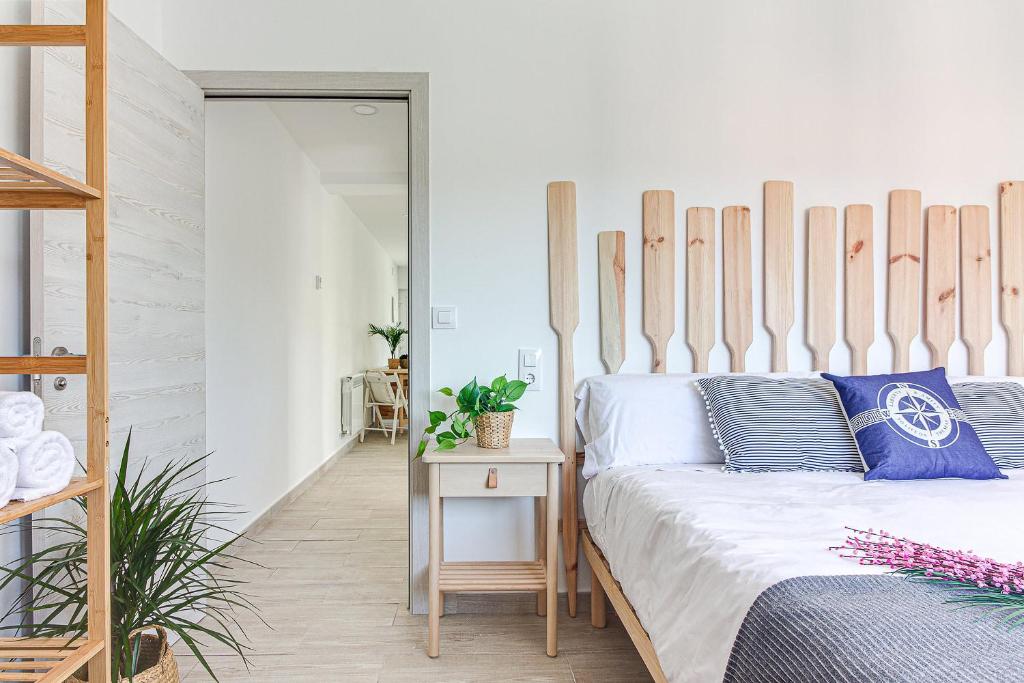 a bedroom with a bed with a wooden headboard at Apartamentos Playa de Finisterre in Fisterra