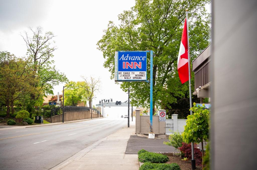 a sign on the side of a street with a flag at Advance Inn in Niagara Falls