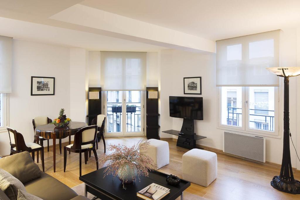 ein Wohnzimmer mit einem Sofa und einem Tisch in der Unterkunft Montmartre Residence in Paris