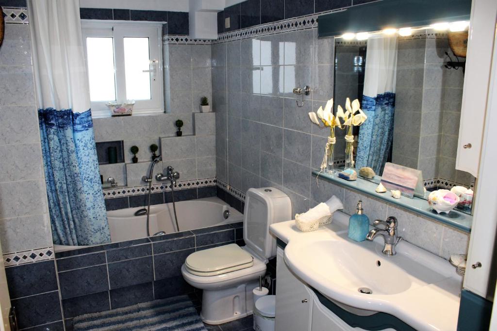 łazienka z umywalką, toaletą i wanną w obiekcie Luxury Sea View w mieście Wolos