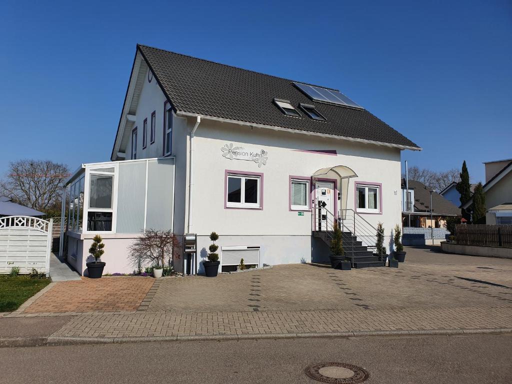 a white house with a black roof at Pension Kuhn in Rust