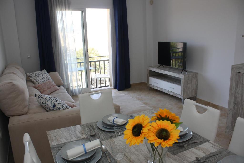 a living room with a couch and a table with sunflowers at Fuente Lebana Labradores in Facinas