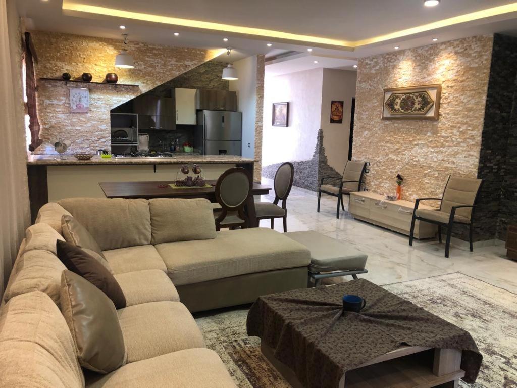 a living room with two couches and a kitchen at For family hacienda bay senior chalet baharey in El Alamein