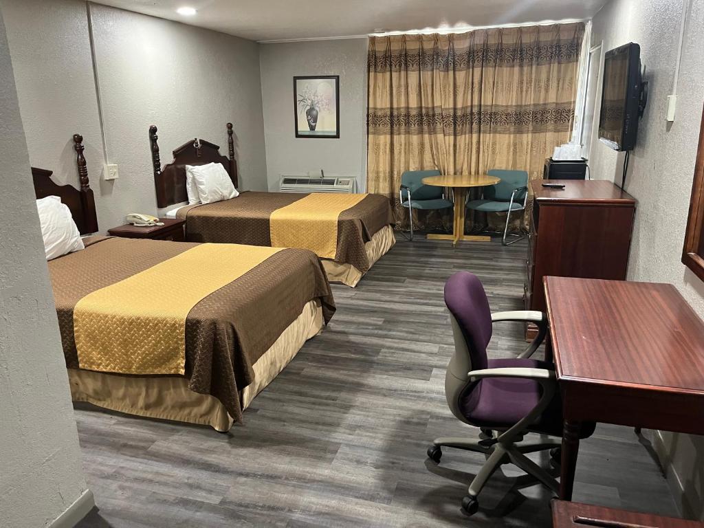 Postel nebo postele na pokoji v ubytování Mid Towne Inn & Suites
