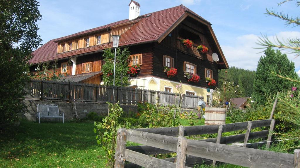 una gran casa de madera con una valla delante de ella en Stoff-Maurergütl, en Mauterndorf