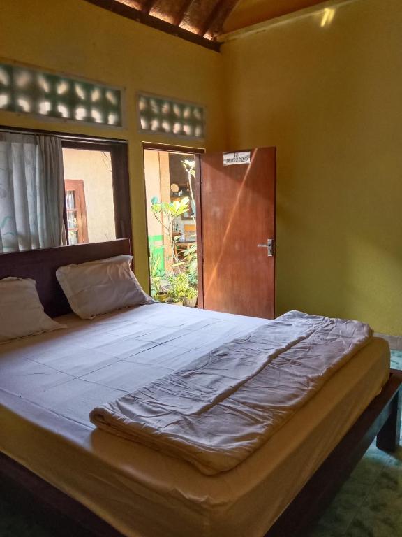 Rúm í herbergi á Agung Pring Homestay